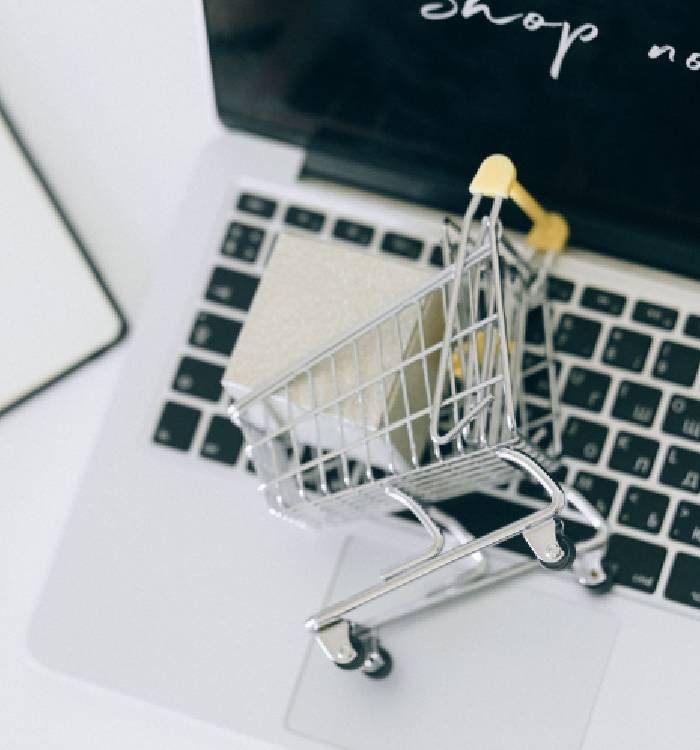 A mini shopping cart on a laptop keyboard